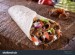 stock-photo-a-delicious-doner-donair-kebab-wrap-with-spicy-meat-lettuce-tomato-red-onion-and-sauce-1489995704